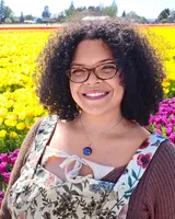 Lindsey Frazier, LMT, smiling in front of a field of tulips