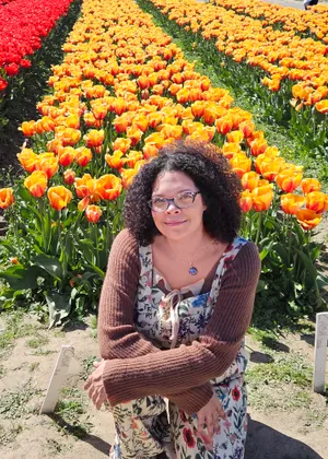 Lindsey Frazier smiling in a field of orange tulips
