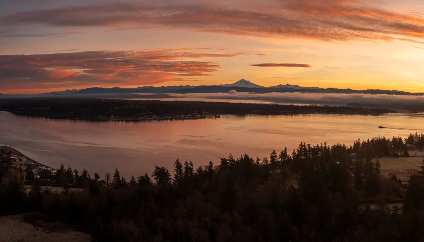 A fiery sunset over Bellingham Bay with Mount Baker on the horizon