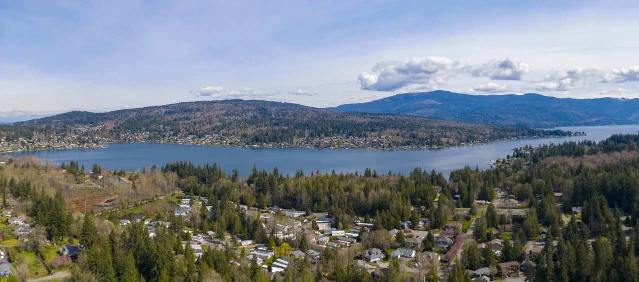 An aerial view of a lake ringed by the forested hills of Bellingham, Washington
